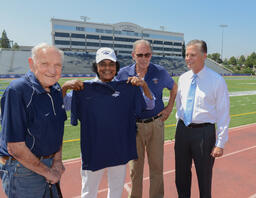 Johnny Mathis and others with University of Nevada, Reno cap and shirt, 1