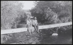 Man and woman sitting on a beam