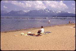 South Lake Tahoe beach with people sitting on towels 