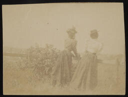 Two women standing at a fence