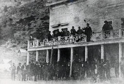 Men posing outside the Alpine Chronicle building in Silver Mountain, California