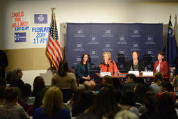 Hillary Clinton and women's healthcare round-table panel listening to audience member, wide view