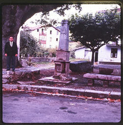 Man standing in front of tree next to obelisk 