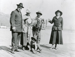 Group of people with a string of fish on a pier at Lake Tahoe