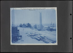 Chief Engineer's Office Photographs Numbers 76-200 page 008, View showing Power House, Rever, Dust Chamber and Stack, American Bridge Company Crane erecting steel in Reverberatory 